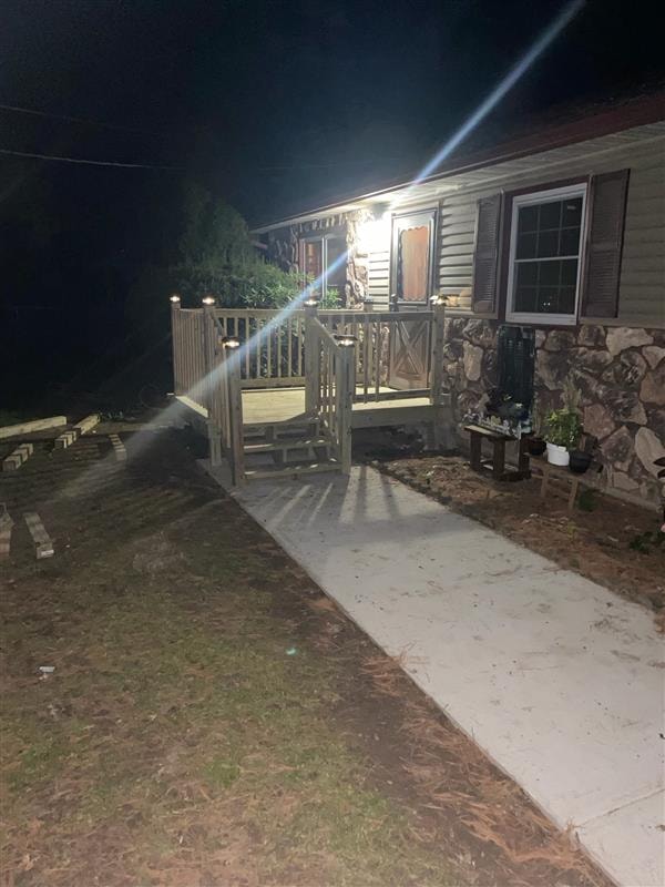 Completed wooden deck and ramp with solar post lights at night