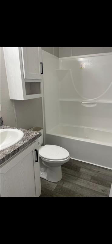 Completed bathroom remodel with tub, toilet, and granite-topped vanity